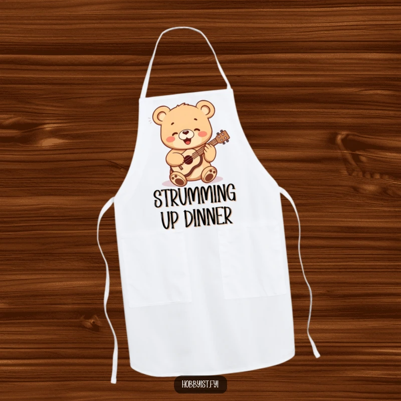 Funny bear cub playing a tiny ukulele while wearing a chef's hat, printed on a functional apron, a unique gift.