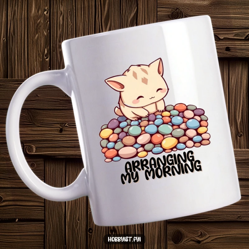 Funny curious creature with pointy ears meticulously arranging colorful pebbles into a pattern, on a cute mug.