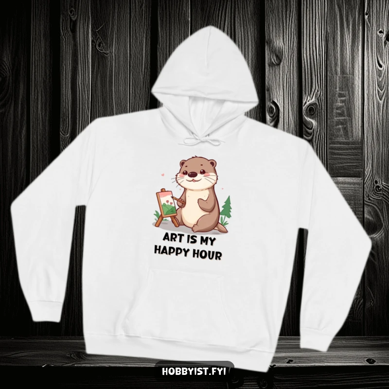 Funny Hoodie with a cheerful otter carefully painting a small, detailed landscape, exuding calm focus and artistic joy.