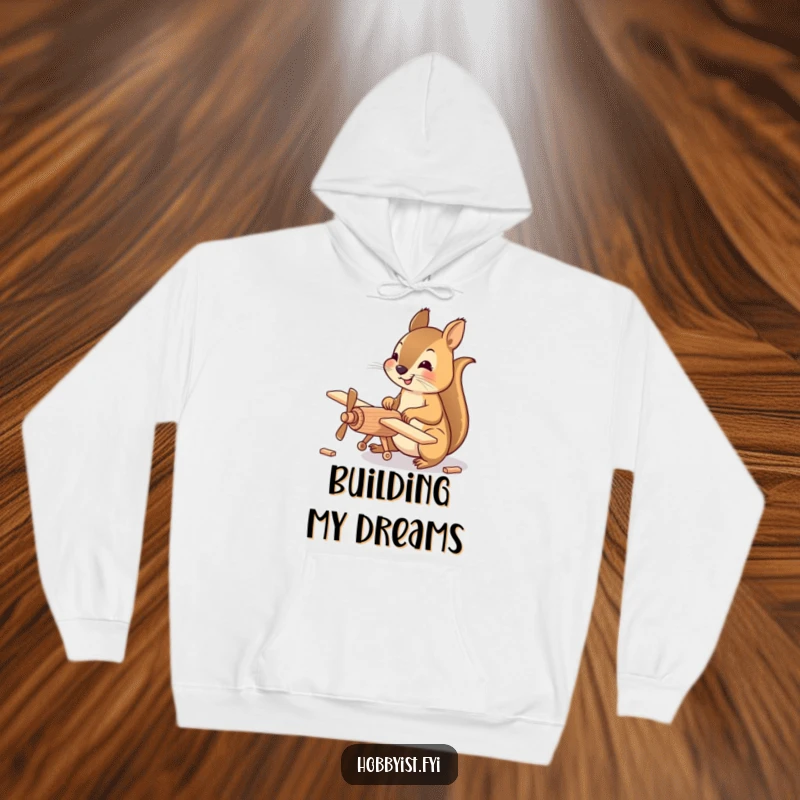Funny Hoodie featuring a happy squirrel meticulously assembling a small wooden model airplane, perfect for staying warm while engaged in detailed work.
