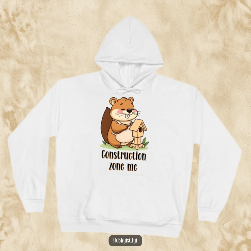 Funny beaver hoodie with apron, happily hammering a miniature birdhouse, offering warm, hilarious DIY vibes.