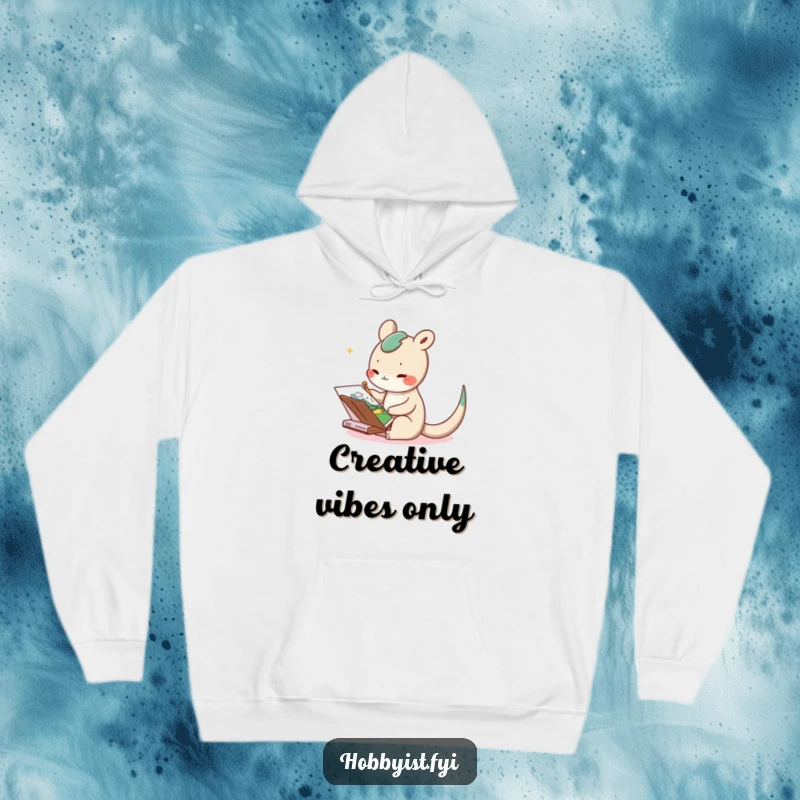 Funny hoodie with a delighted long-tailed creature joyfully sketching a whimsical landscape in a notebook, offering warmth and art
