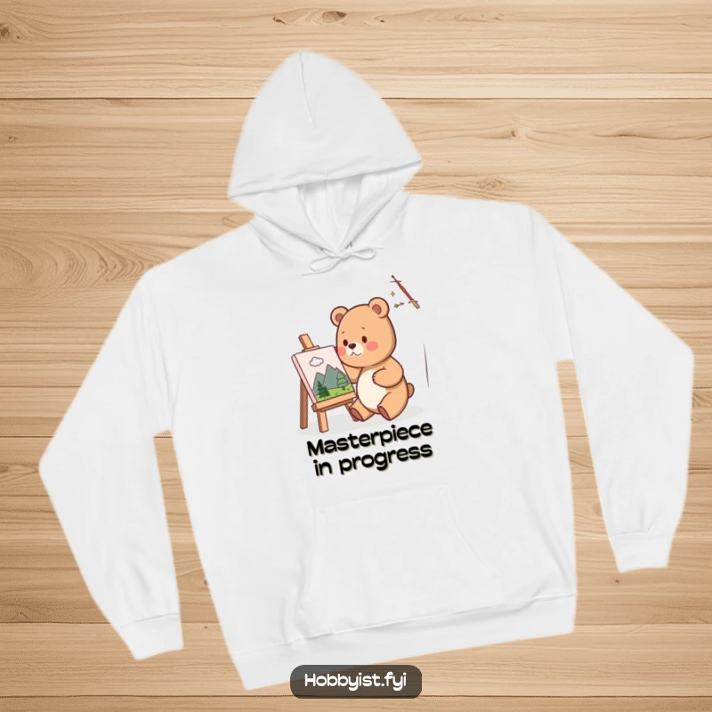 Funny Hoodie showcasing a cute bear artist happily painting a miniature landscape on a small canvas, radiating warmth and artistic passion.