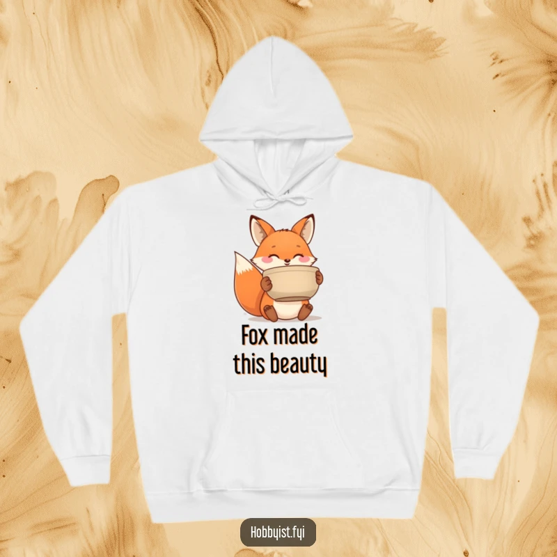Funny hoodie featuring a beaming fox proudly holding a handmade ceramic pot, perfect for cozy creative days.