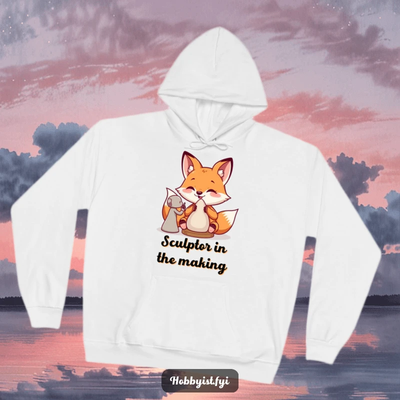 Funny hoodie with a giddy fox sculptor engrossed in creating a clay figure, embodying artistic joy and humorous inspiration.