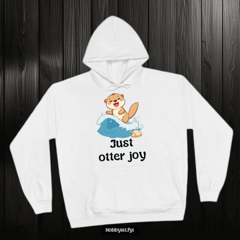 Funny Otter Hoodie shows a giggling otter riding a miniature wave towards a seashell, perfect for cozy aquatic fun.