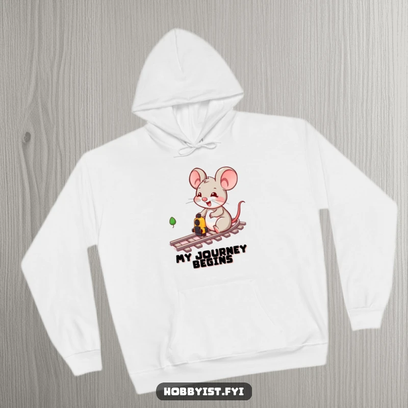 Funny, cheerful mouse character actively playing with a miniature train set, pictured on a comfortable and warm hoodie.