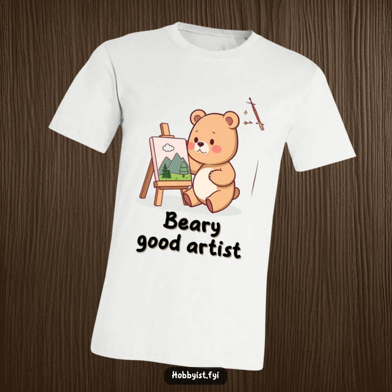 Funny T-Shirt with a cute bear artist happily painting a miniature landscape on a small canvas, embodying artistic joy and concentration.