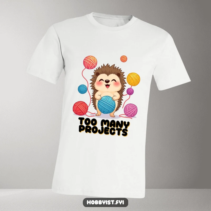 Funny T-Shirt depicting a giggling hedgehog in mid-air, skillfully juggling multiple colorful yarn balls with delight.