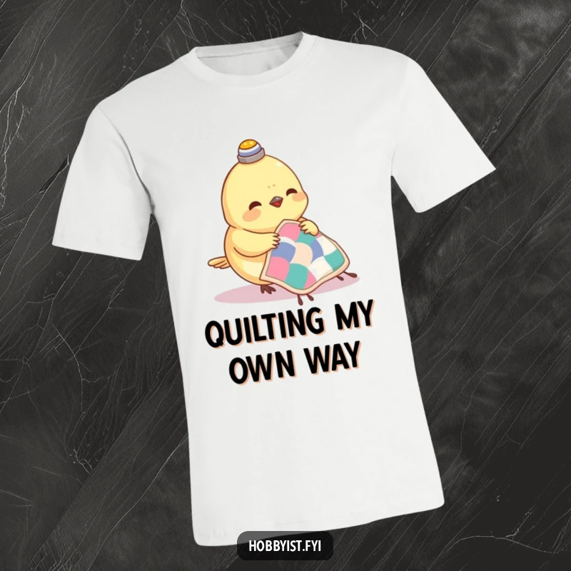 Funny Hazelnut T-Shirt featuring a small bird wearing a thimble on its head, happily sewing a miniature quilt with focus.