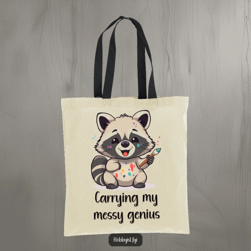 Funny reusable tote bag featuring a delighted raccoon with paint splatters, holding a brush, perfect for artists and expressive shoppers.